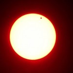 Daily Mail caption: Last-in-a-lifetime: In this photo made using a red filter, Venus begins to pass in front of the sun, as visible from from Overland Park, Kan. on Tuesday