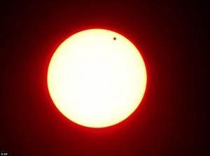 Daily Mail caption: Last-in-a-lifetime: In this photo made using a red filter, Venus begins to pass in front of the sun, as visible from from Overland Park, Kan. on Tuesday