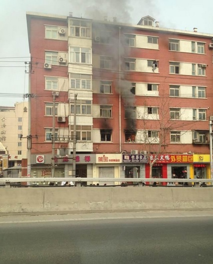 Beijing man hangs off building on fire, falls 2