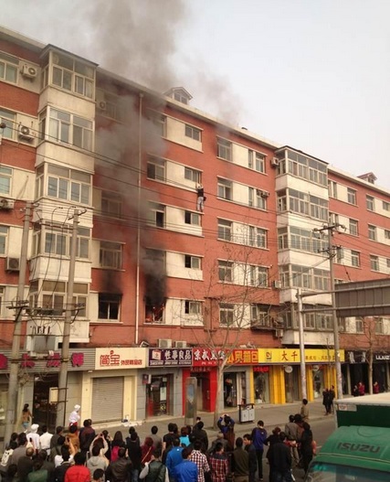 Beijing man hangs off building on fire, falls 3