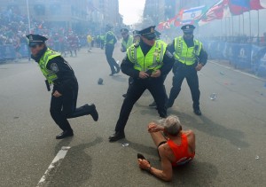 Police officers run with their guns drawn as they hear the second explosion down the street. (John Tlumacki/Globe Staff)