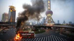 A double-decker tourism bus is seen on fire in from of the Oriental Pearl Tower in the Pudong financial district of Shanghai