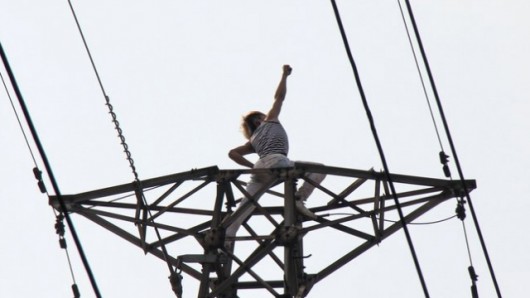 Man poses on electricity tower