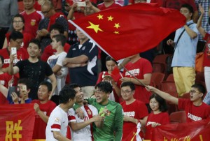 China's Hao Junmin, China's Zheng Zhi and China's goalkeeper Wang Dalei celebrate their win over Uzbekistan after their Asian Cup Group B soccer match at the Brisbane Stadium in Brisbane